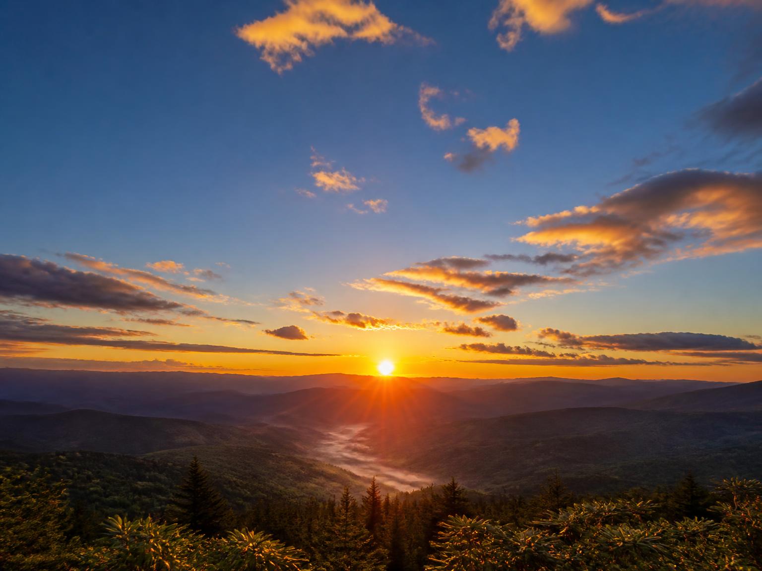 Sunrise over layered blue ridge mountains